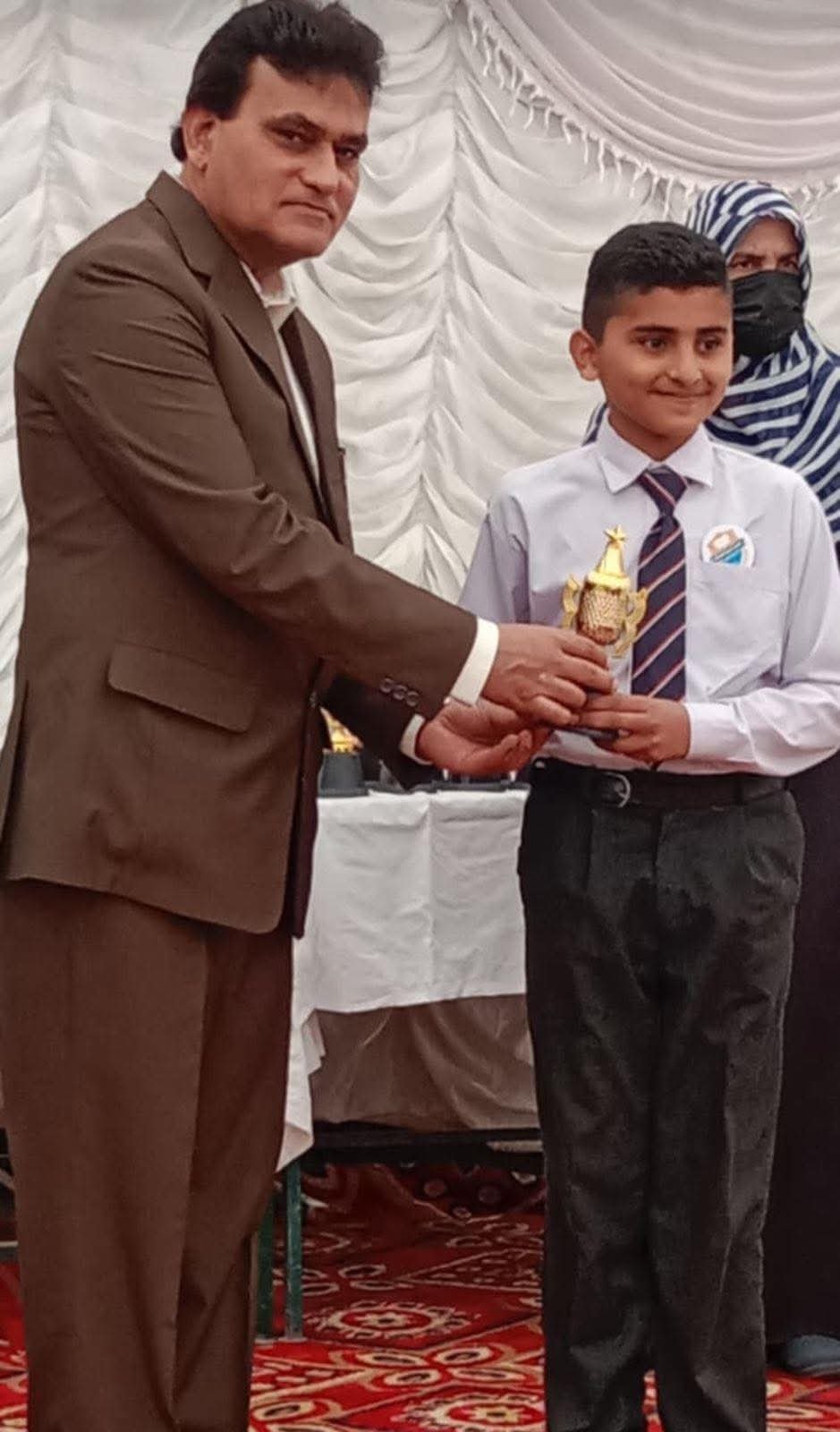 Student receiving an achievement award at Modern Public School